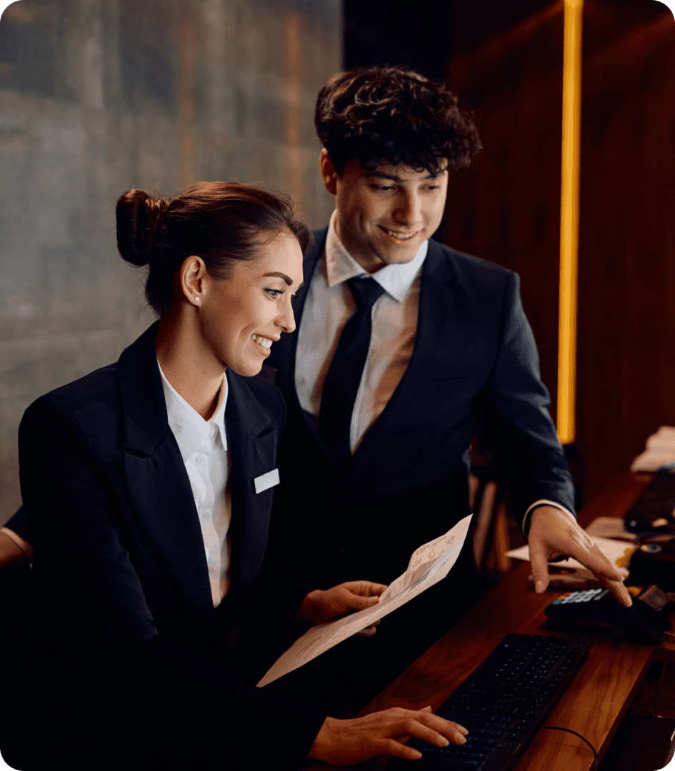 Hotel receptionists working at a desk.